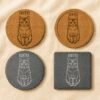 Flat lay comparison image showing four personalized pet coaster options in different materials and shapes, including round cork, recessed-edge cork, round slate, and square slate designs engraved with a cat portrait and the name Coffee.
