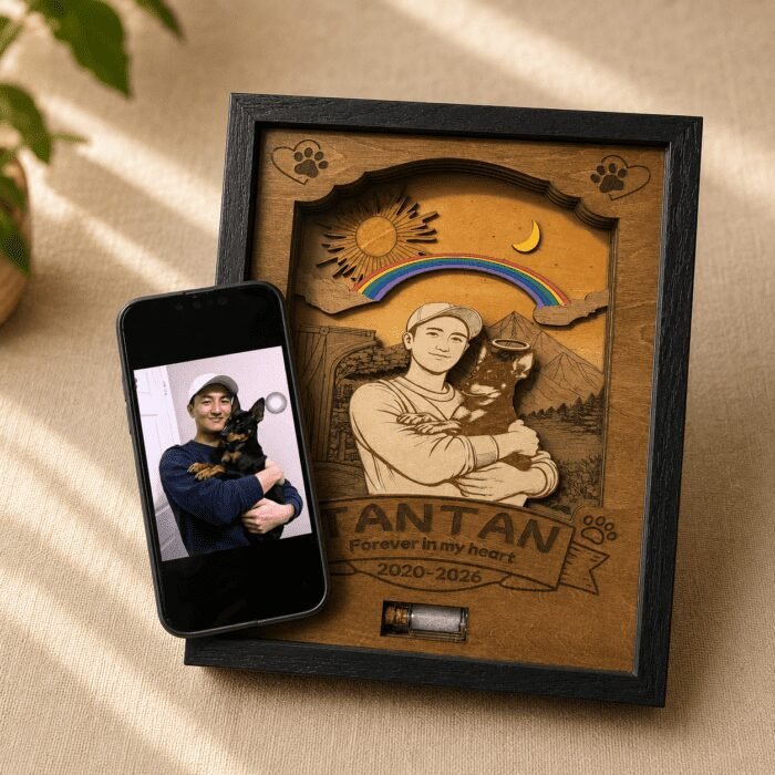 Personalized wooden pet memorial shadow box displayed beside the original reference photo on a smartphone, showing custom portrait engraving transformation.