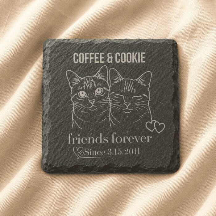 Personalized engraved square slate pet memorial coaster featuring custom cat portrait artwork, family name engraving, and commemorative text displayed on soft cream linen fabric.