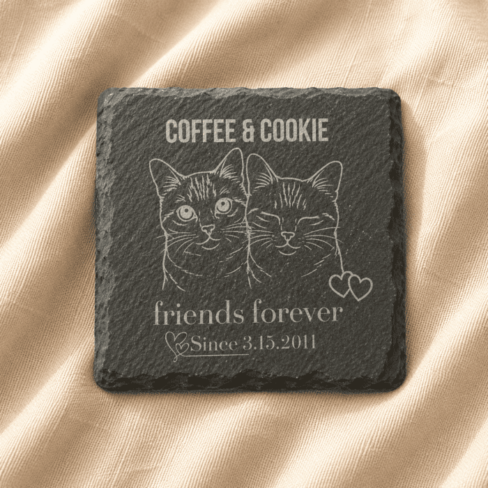 Personalized Engraved Slate Pet Memorial Coaster with Custom Pet Portrait Personalized engraved square slate pet memorial coaster featuring custom cat portrait artwork, family name engraving, and commemorative text displayed on soft cream linen fabric.