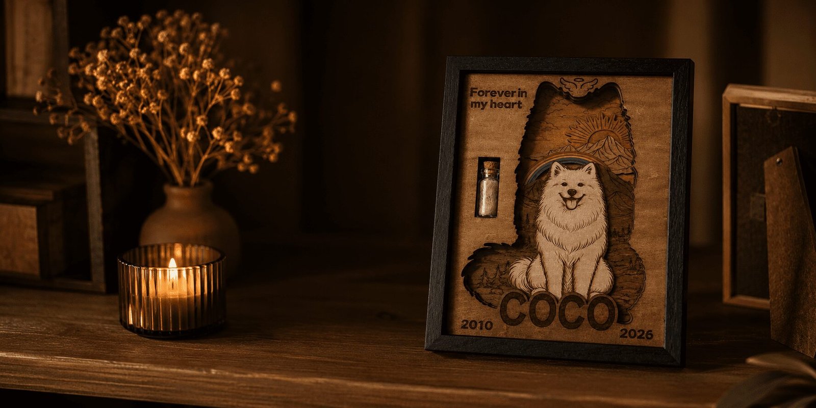 Warm moody product photograph of a handcrafted wooden pet memorial shadow box displayed on a dark wooden table beside a glowing candle and dried flowers, featuring a personalized dog keepsake with a fur vial and rainbow bridge design.
