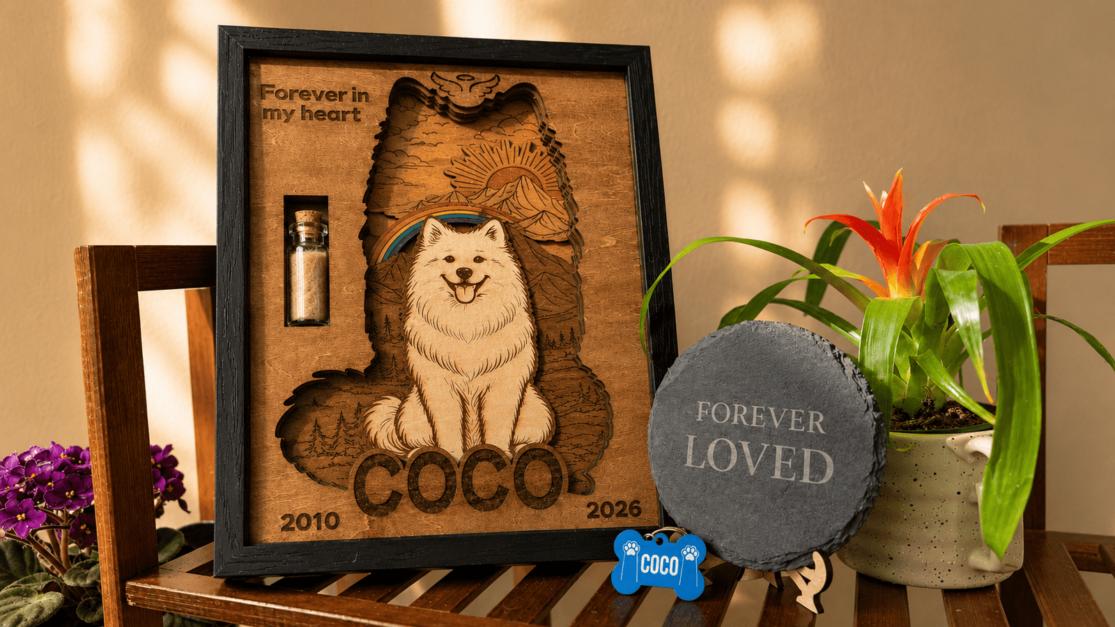 Warm lifestyle display of a personalized wooden pet memorial shadow box styled with a memorial slate coaster, custom pet tag, and houseplants on a wooden bench.