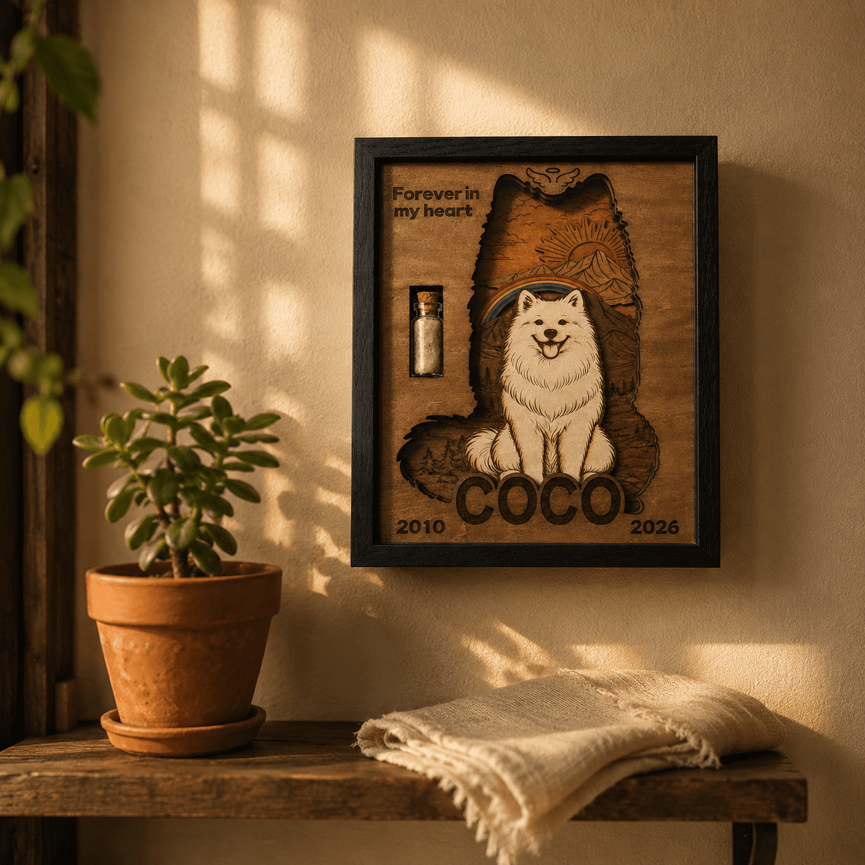 Warm lifestyle photo of a personalized wooden pet memorial shadow box being held in both hands on a cozy blanket in soft indoor lighting.