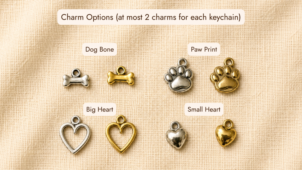 Customizable pet memorial keychain charm options displayed on cream linen fabric, including dog bone, paw print, heart outline, and small heart charms in silver and gold finishes.
