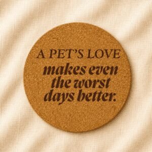 Round cork coaster featuring the engraved quote “A pet’s love makes even the worst days better” in mixed serif and bold italic typography on a warm cream linen background.