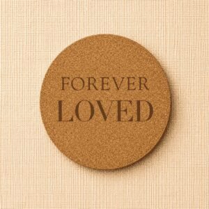 Round cork pet memorial coaster engraved with the words “Forever Loved” on a neutral linen background, a natural remembrance keepsake for honoring a beloved dog or cat.