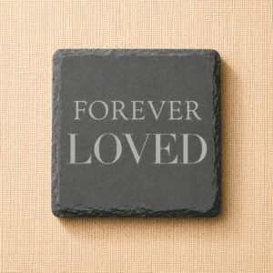 Square slate pet memorial coaster engraved with the words “Forever Loved” on a neutral linen background, a timeless remembrance keepsake for honoring a beloved dog or cat.