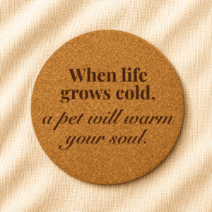 Round cork coaster featuring an engraved inspirational pet quote in bold serif and elegant italic typography on a warm cream linen background.