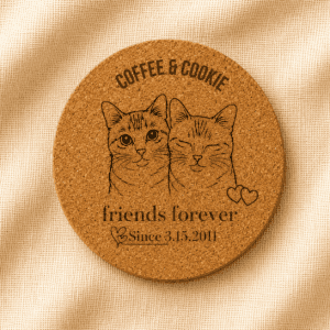 Round personalized cork coaster featuring custom engraved portraits of two orange cats, Coffee and Cookie, with the phrase “Friends Forever” and a special date, displayed on a soft cream linen background.