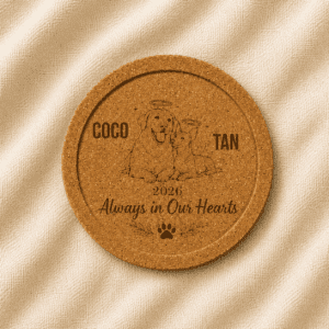 Personalized round cork pet memorial coaster with recessed edge, featuring custom engraved dog and cat portraits, pet names, memorial year, and the quote “Always in Our Hearts,” displayed on a soft linen background.